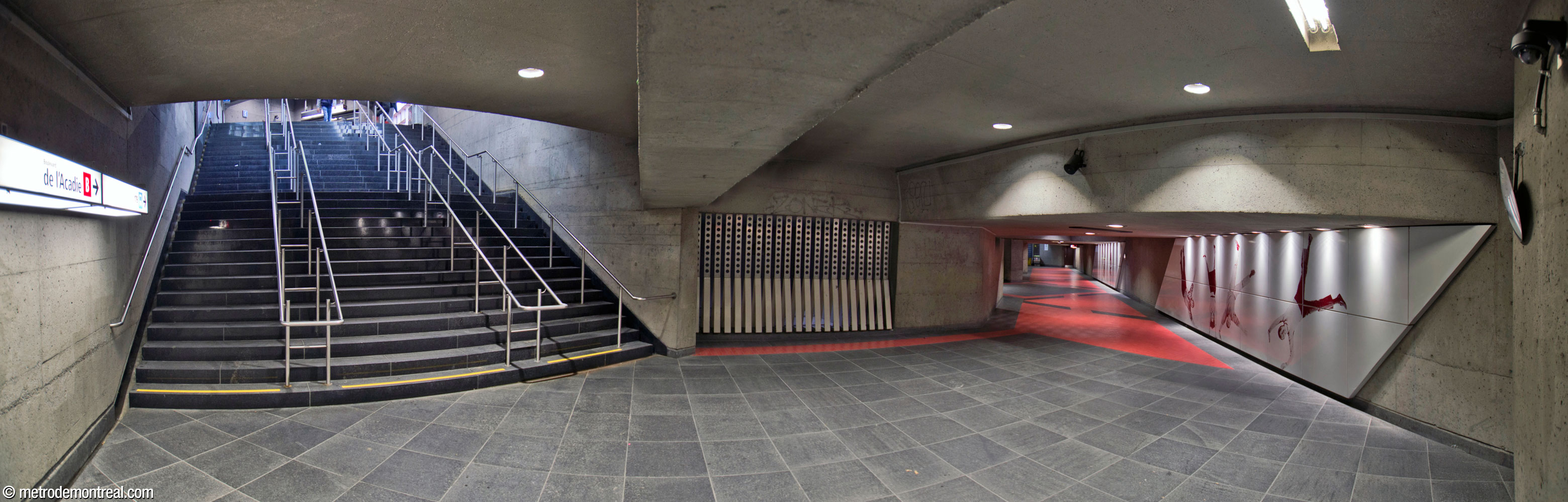 The passage connecting the De l'Acadie headhouse (left) with the rest of the station. The grille at centre is one of the overlooks from the passage onto the ticket hall volume. The passage floor is tiled with the same red and black ceramic tiles as the platforms, and the wall features two of the sections of Jean Mercier's mural artwork.