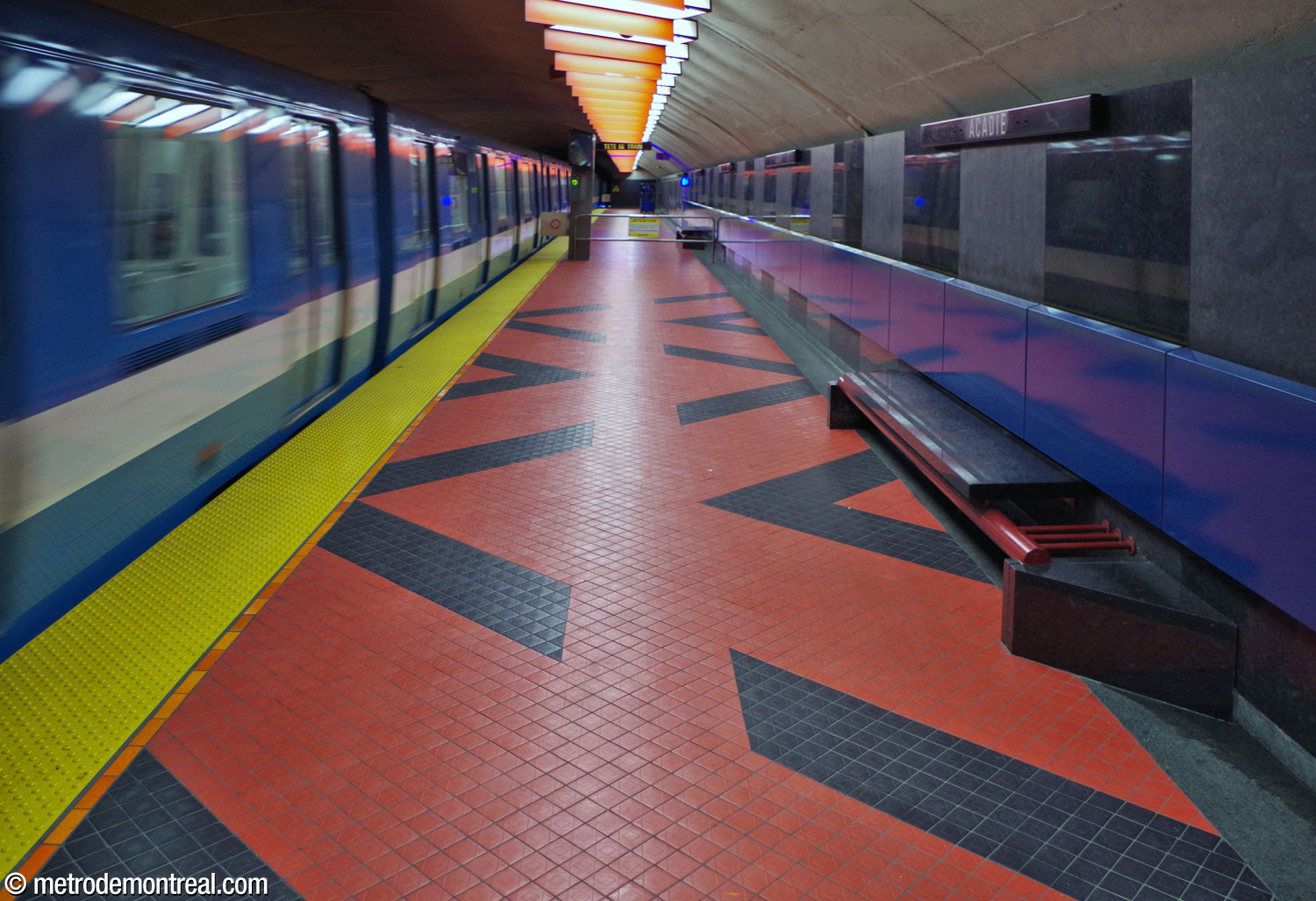 A train departs from the Saint-Michel platform. At right, one of the distinctive platform benches in black granite and red-painted metal, designed by Michel Morelli.
