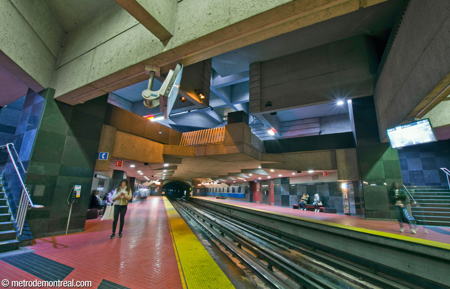 Looking up from the Saint-Michel platform to the main volume and mezzanine above. The end of the mezzanine juts out in a prow-shaped point over the tracks.