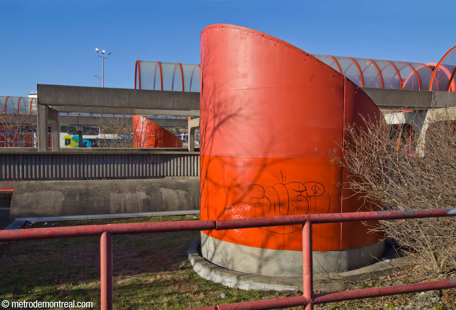 The walkway at the southwestern end of the station is flanked by two huge, bright orange ventilation shafts.