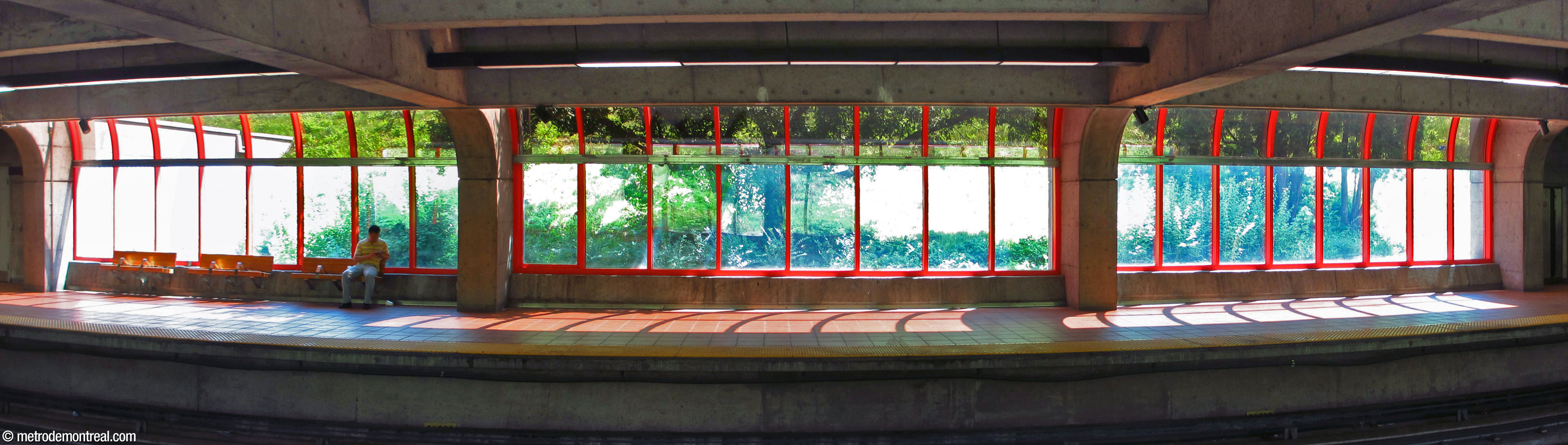At platform level, rows of windows at either end of each platform admit sunlight and overlook a landscaped slope beyond.