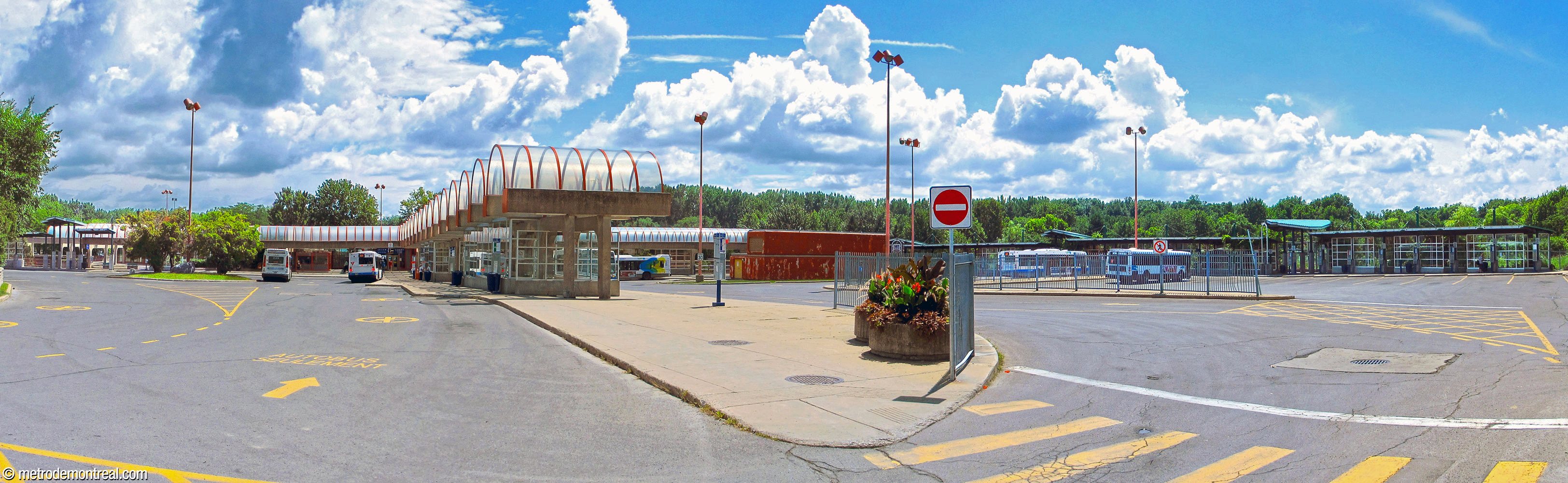 Panoramic view of the bus terminal, showing the domed central pier linked to the station headhouse. At right, the far wing and its shelter were built after the original station and are in a different style, as are some other extensions surrounding the station.