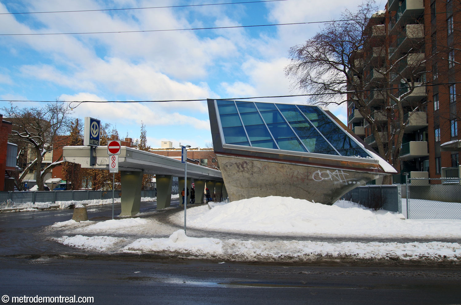 Derrière la station se dresse une grande lanterne en forme de pyramide inversée et tordue. La boucle d'autobus et sa colonnade passent à côté.