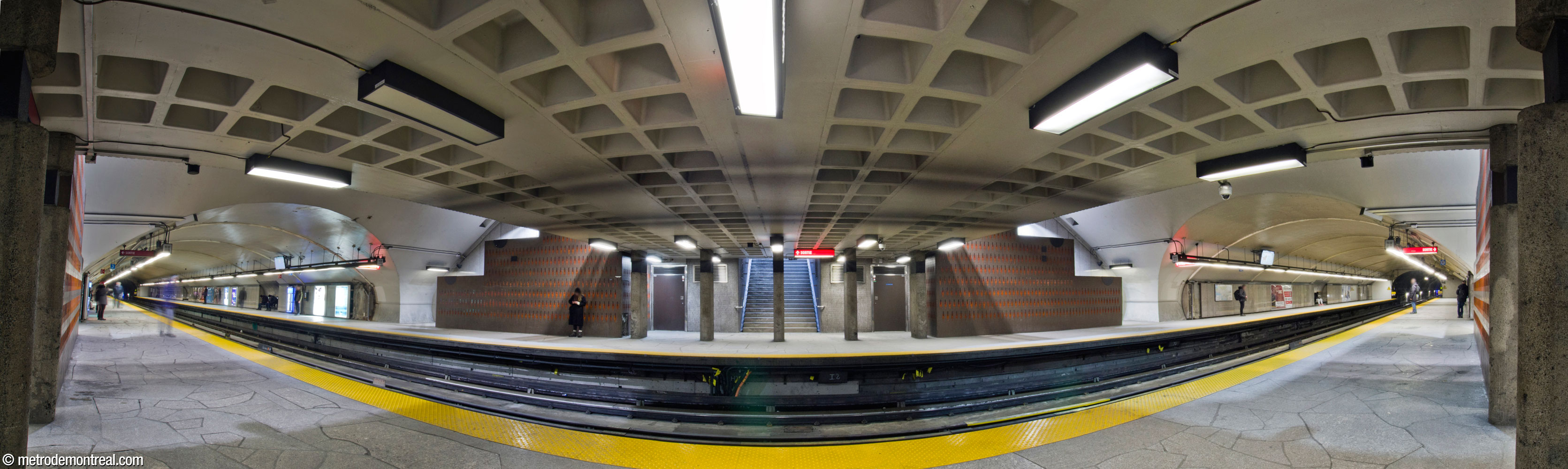Panorama de la nef à partir du quai Côte-Vertu. Les sections construites en tunnel sont soulignées par la forme ovale créée par leur intersection avec la voûte du transept. Chacun des quais est relié au niveau de la passerelle par deux escaliers latéraux et un escalier central. De part et d'autre de la passerelle, des murs-écran dissimulant les escaliers latéraux sont parés de carrelage céramique, l'œuvre de Claude Vermette.