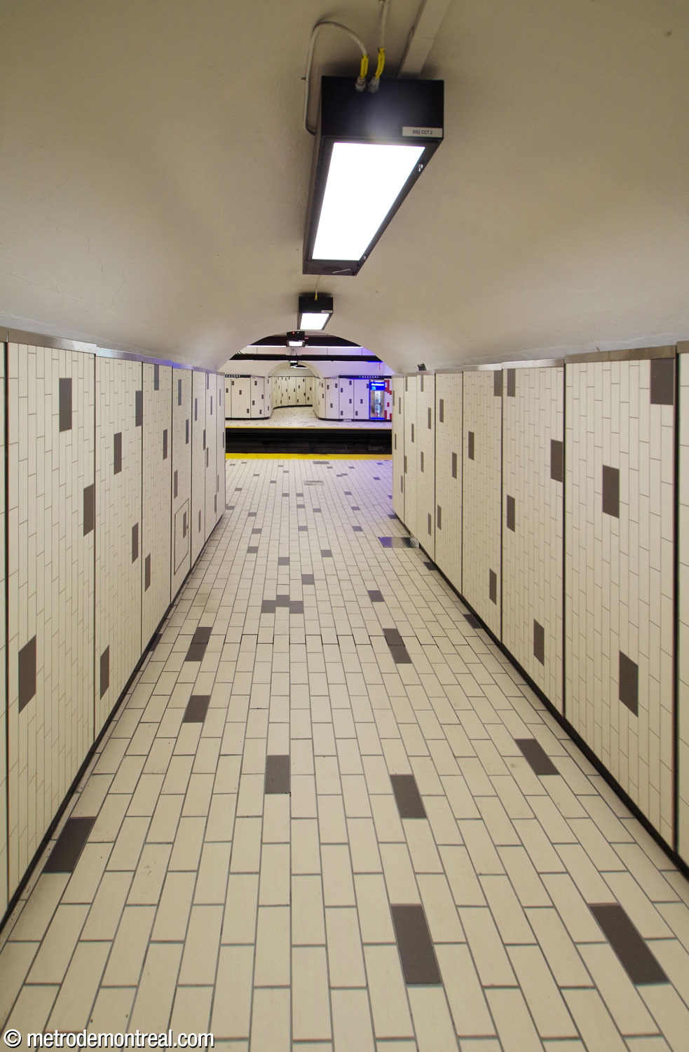 Vue depuis un couloir d'accès sur les quais et le couloir en face.