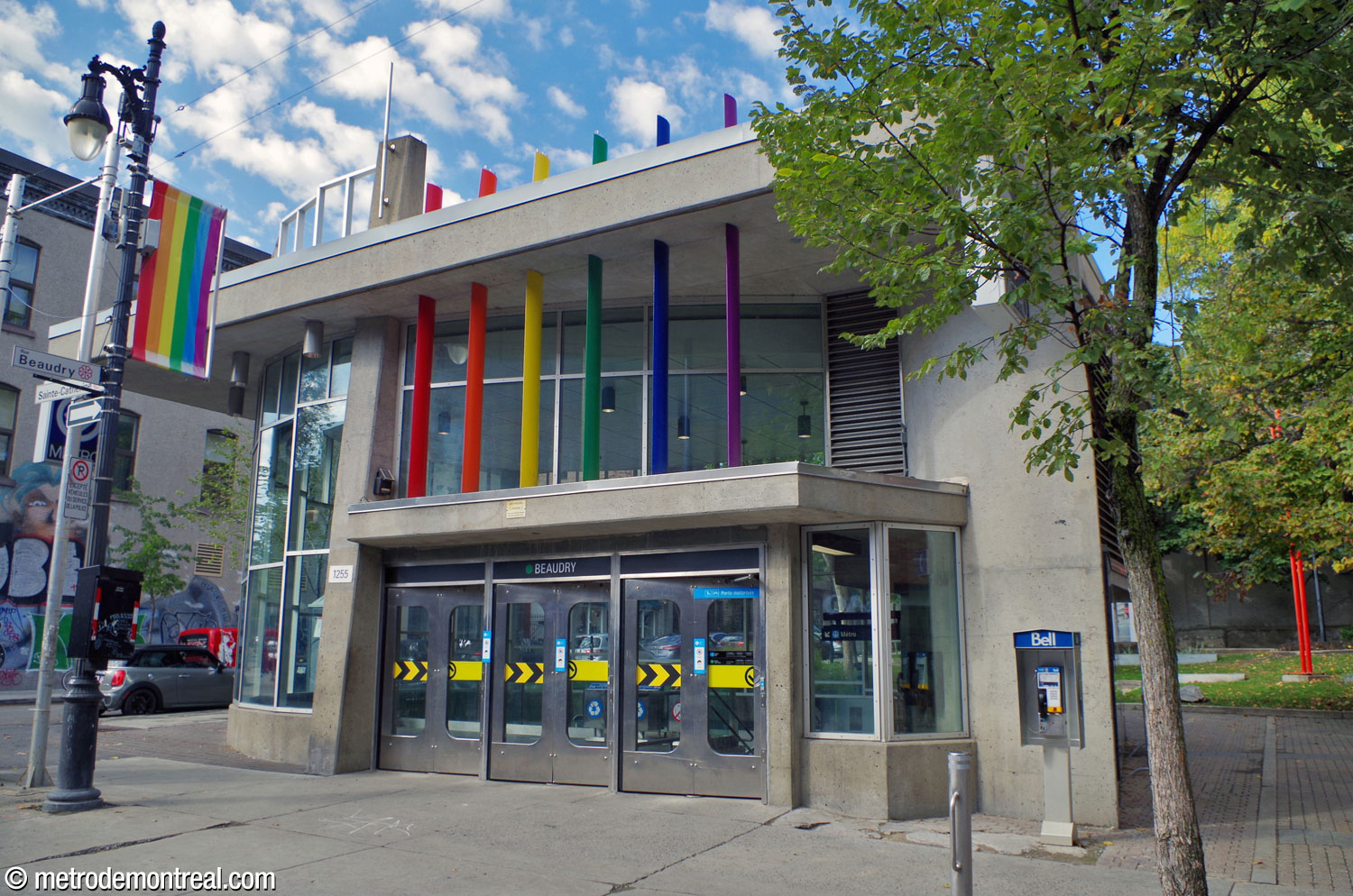 Façade de l'édicule sur la rue Sainte-Catherine, montrant les mâts arc-en-ciel au-dessus de l'entrée.