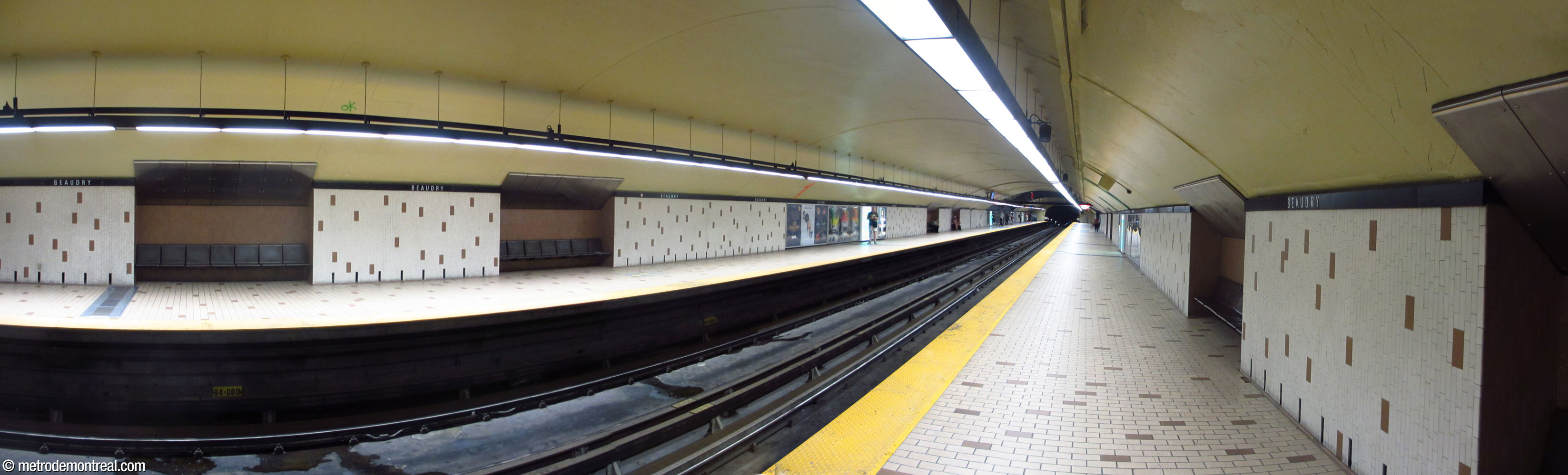 Décor de la station avant 2019 : carrelage crème et brun des quais, sièges noirs sur fond brun.
