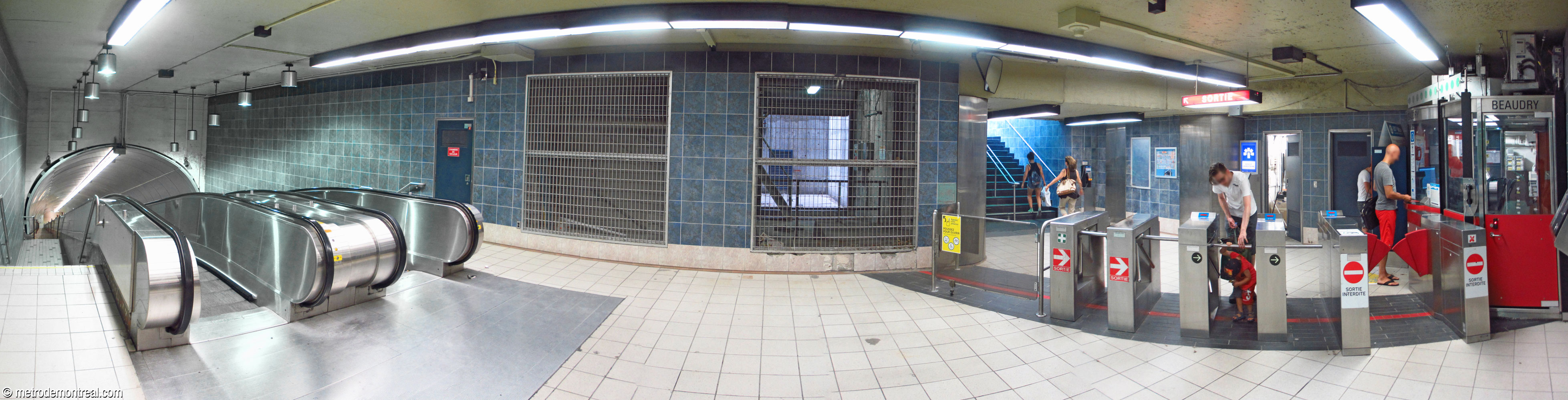 Décor de la station avant 2019 : le carrelage mural bleu ardoise et le plancher blanc de la billetterie.