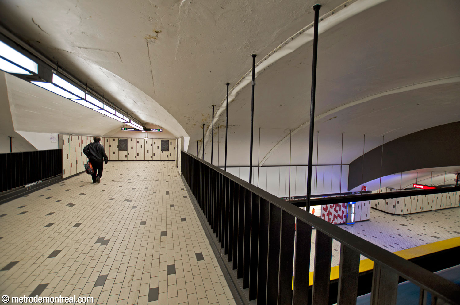 Vue vers l'extrémité de la passerelle, montrant la sortie du couloir d'accès au niveau du quai. La voûte de la nef dans cette section est surélevée.
