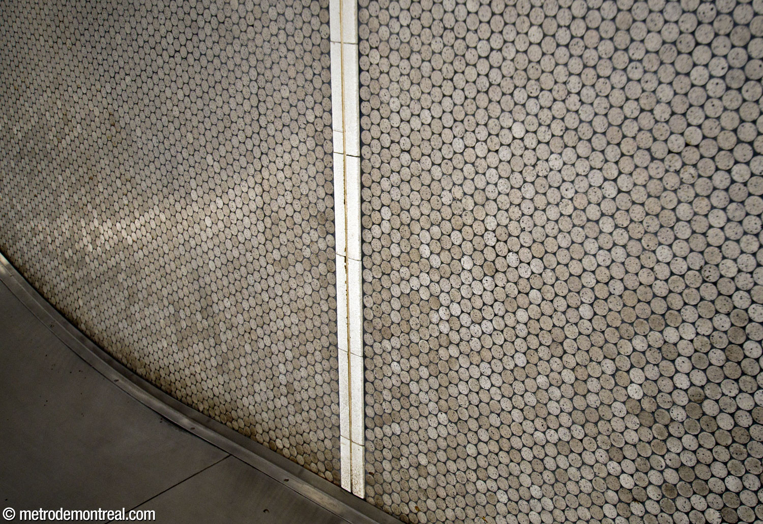 Les pastilles grises qui paraient les murs de la station avant les rénovations de 2010-2021. La dernière section de ce revêtement qui subsiste se trouve au niveau de la cage d'escalier vers la sortie Gare d'Autocars.