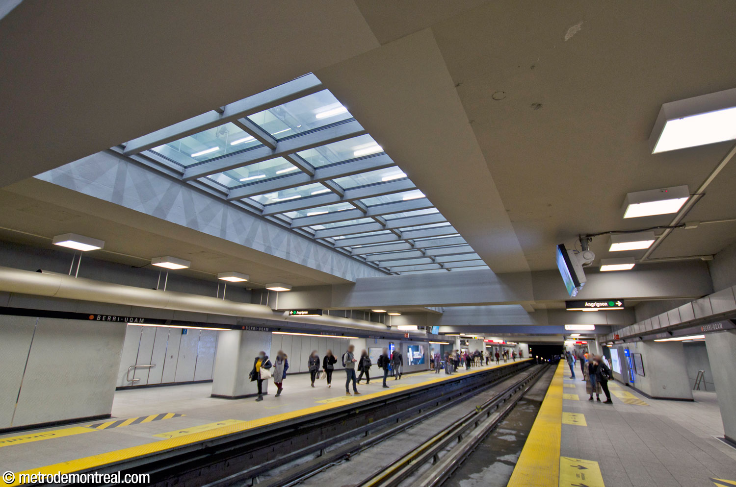L'extrémité nord des quais de la ligne orange, pourvue de collatéraux de part et d'autre. Celui du quai Montmorency offre un deuxième accès au quai à partir du palier, aidant à mieux répartir le long des quais les foules importantes de l'heure de pointe du soir. Du côté Côte-Vertu, un escalier secondaire vers le centre du quai Angrignon aide à drainer rapidement les afflux ponctuels suite à l'arrivée des trains durant la période de pointe matinale. Au-dessus, la percée visuelle (désormais vitrée) à partir du couloir nord au niveau de la billetterie.