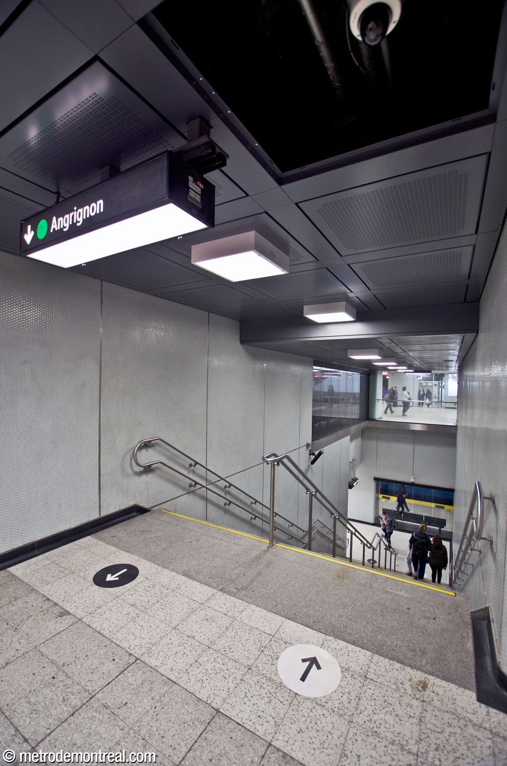 L'escalier secondaire entre les quais Côte-Vertu et Angrignon. La section coudée au pied de l'escalier permet de disperser les foules plus graduellement afin d'empêcher l'affluence excessive sur le quai de la ligne verte.