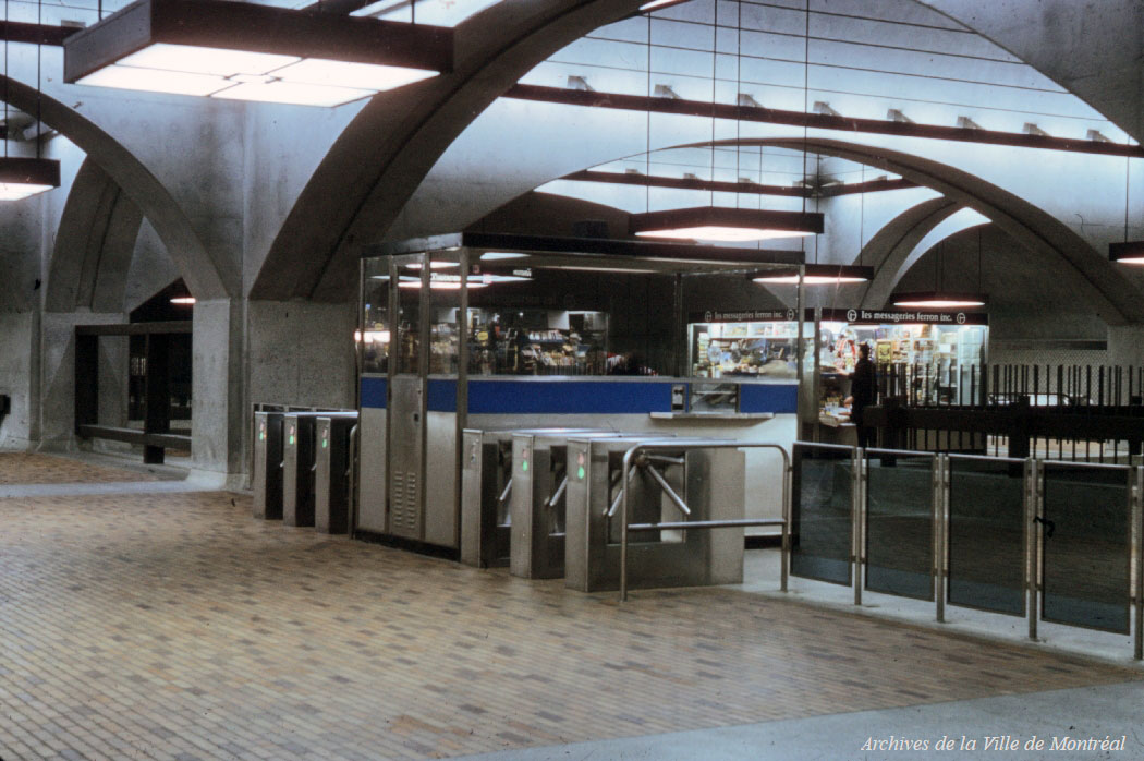 L’ancien aménagement des tourniquets de la station. Ils étaient alors disposés en ligne droite entre les colonnes encadrant la loge, plutôt qu’en V avec la loge adossée au mur du fond comme aujourd’hui. On note également l'apparence ancienne des éléments d'éclairage, avant l'ajout des sommets pyramidaux.
