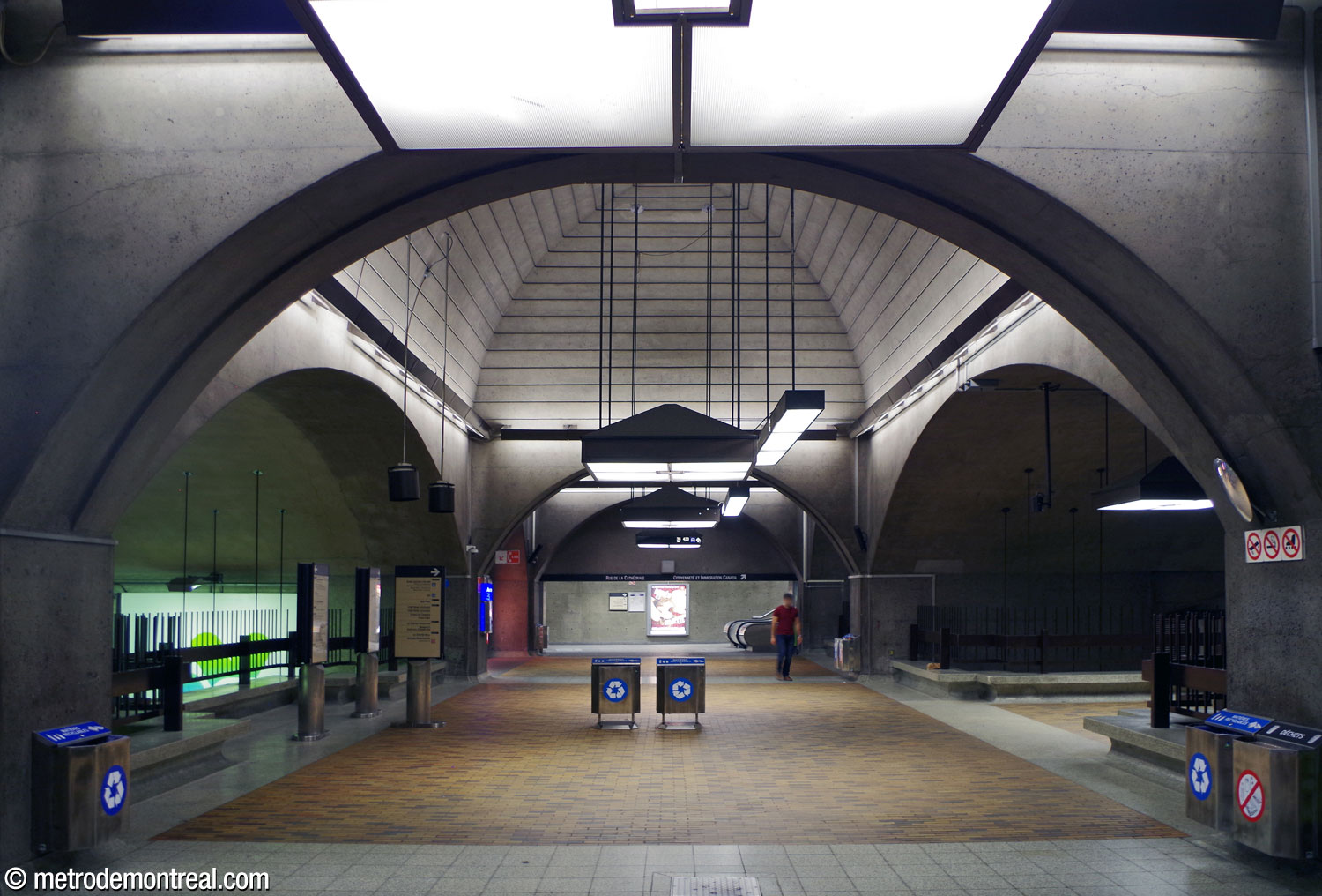 La voûte transversale à l'est de la mezzanine rejoint les accès vers Le 1000 De La Gauchetière, la Place Bonaventure et la gare Centrale (derrière le photographe), les quais centre et sud du terminus Rive-Sud (au fond à gauche) et la sortie de la Cathédrale (au fond au centre). La croisée des deux voûtes est coiffée par une coupole. La mezzanine forme une passerelle vers la billetterie, à droite, et surplombe les quais à gauche.