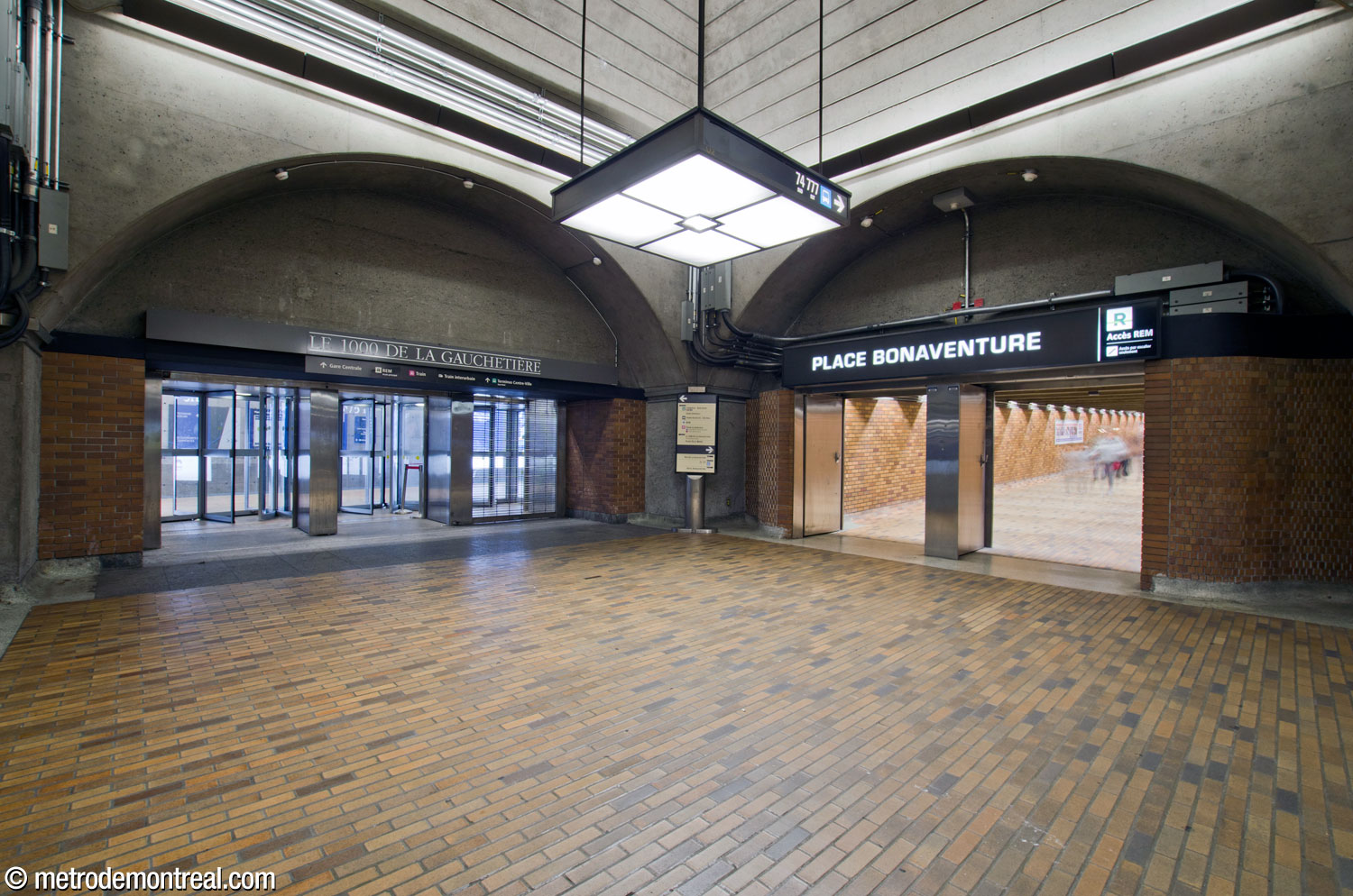 La travée nord-est de la mezzanine rejoint le long tunnel vers la Place Bonaventure (droite), ainsi que l'escalier vers le lien souterrain plus récent avec la gare Centrale, la Place Bonaventure, le 1000 De La Gauchetière et le quai nord du terminus Centre-Ville (gauche).