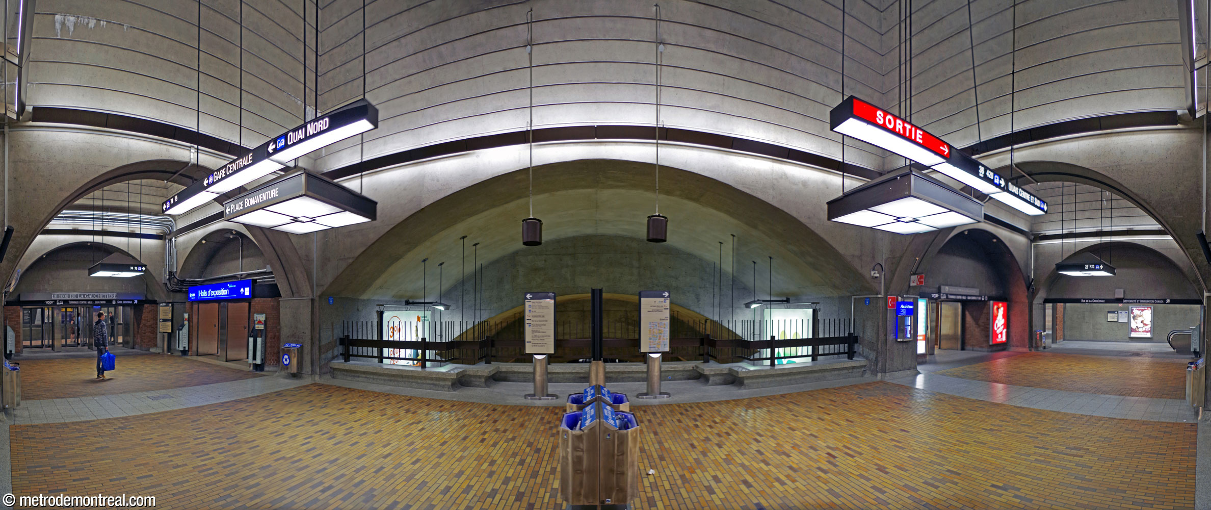 Panorama de la voûte transversale est. À gauche, le passage rejoint les liens vers la Place Bonaventure, la gare Centrale et le 1000 De La Gauchetière; à droite, les quais centre et sud du Terminus Centre-Ville ainsi que la sortie de la Cathédrale.