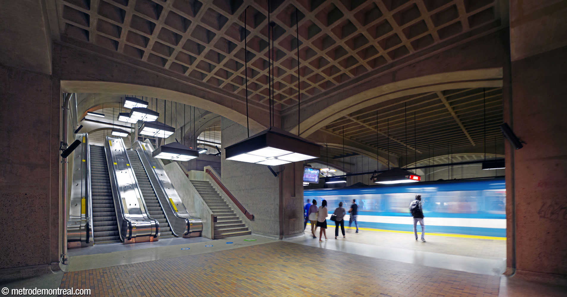 Le pied des escaliers entre la billetterie et le quai Côte-Vertu occupe une travée de la voûte collatérale nord de la station.