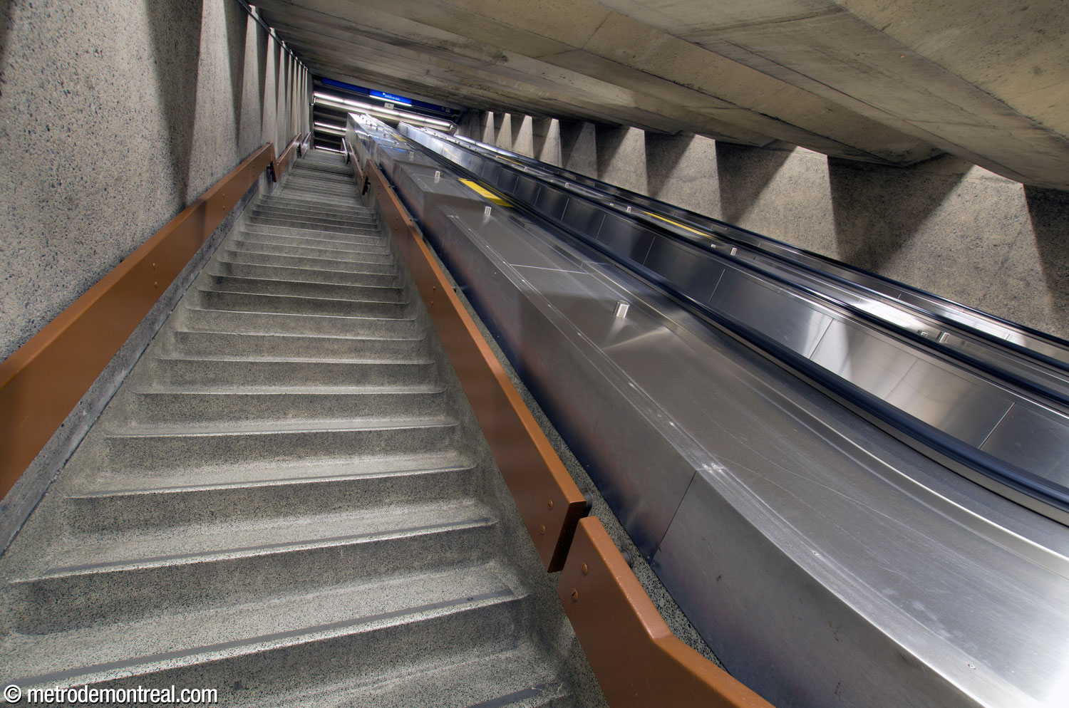 La longue volée d'escaliers fixes et mécaniques au plafond bas, située au bout du tunnel vers la Place Bonaventure et, désormais, la station du REM.