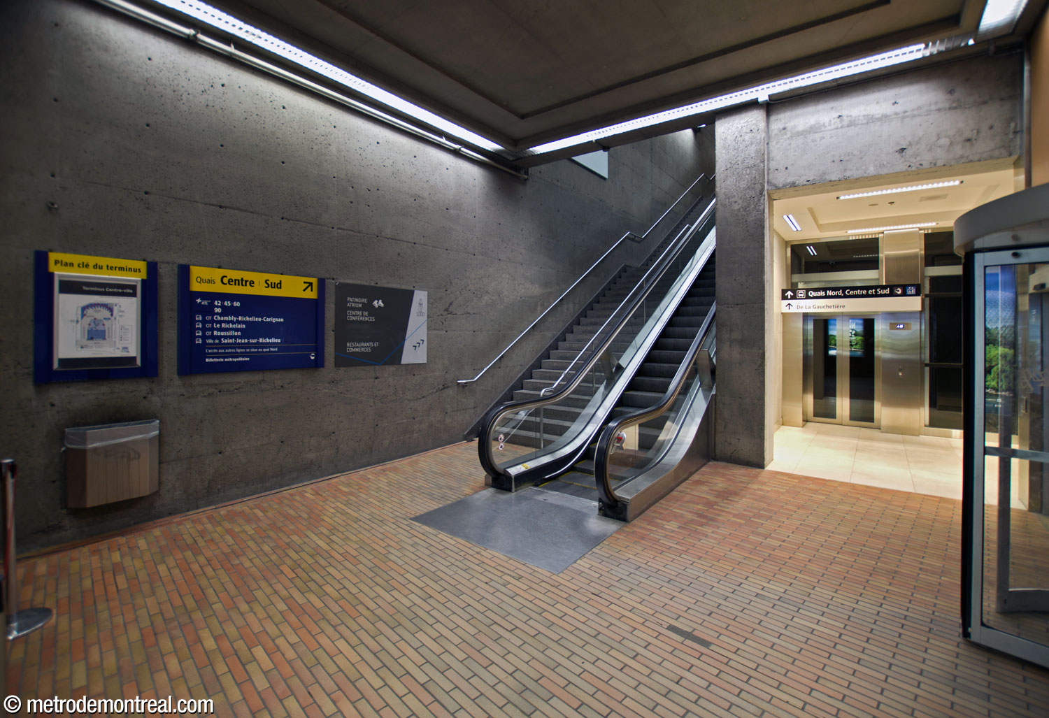Pied de l'escalier et de l'ascenseur entre le niveau mezzanine de la station et les quais centre et sud du terminus Centre-Ville.