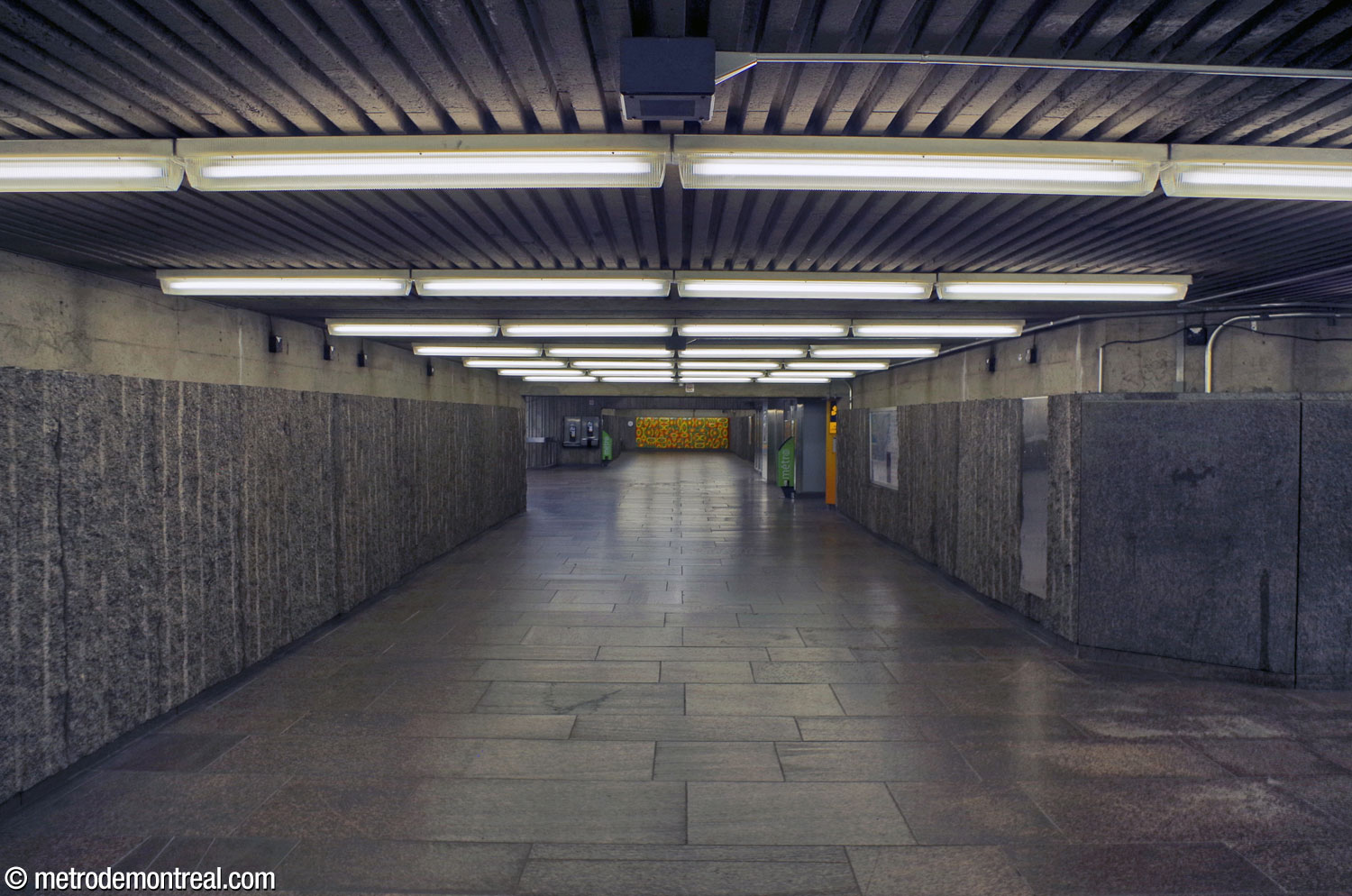 The hallways connecting each of the two accesses to the ticket hall are set in the same axis. Here, a view from the north access toward the south. Far at the other end, the mural by Jean Cartier faces the hallway axis.