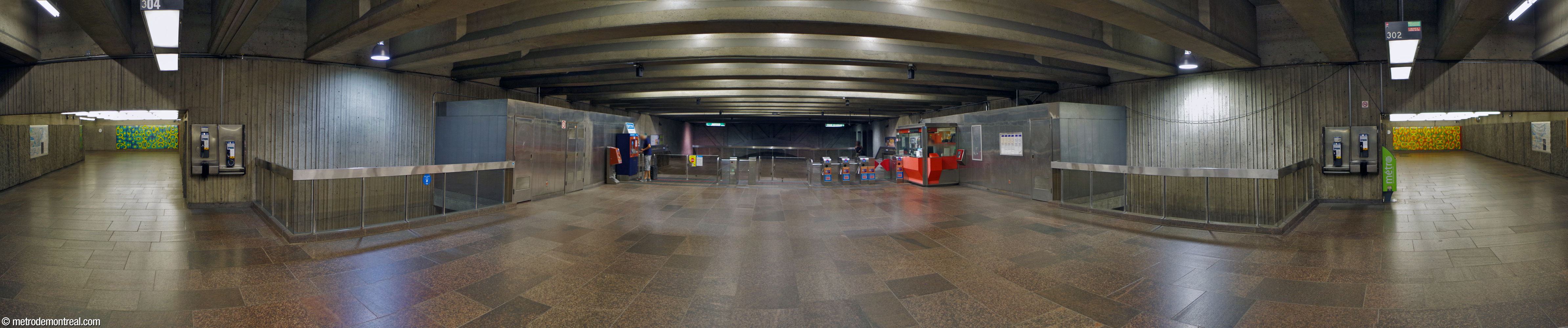 Panorama of the ticket hall looking east, with the north (left) and south (right) access hallways and their murals by Jean Cartier. Staff areas are clad in polished stainless steel.