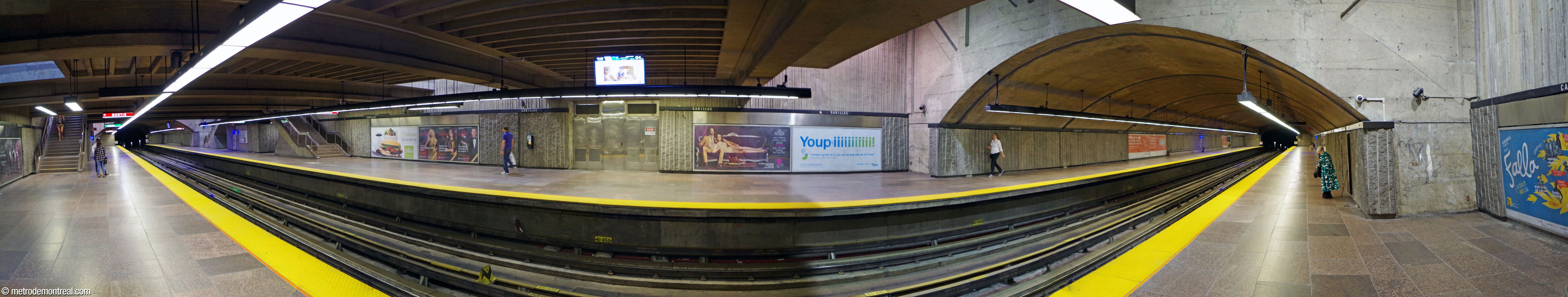 Panorama of the platforms seen from the Angrignon platform under the mezzanine, showing the sections at either end which were built in tunnel. The spandrel wall at right faces the rear of the mezzanine.