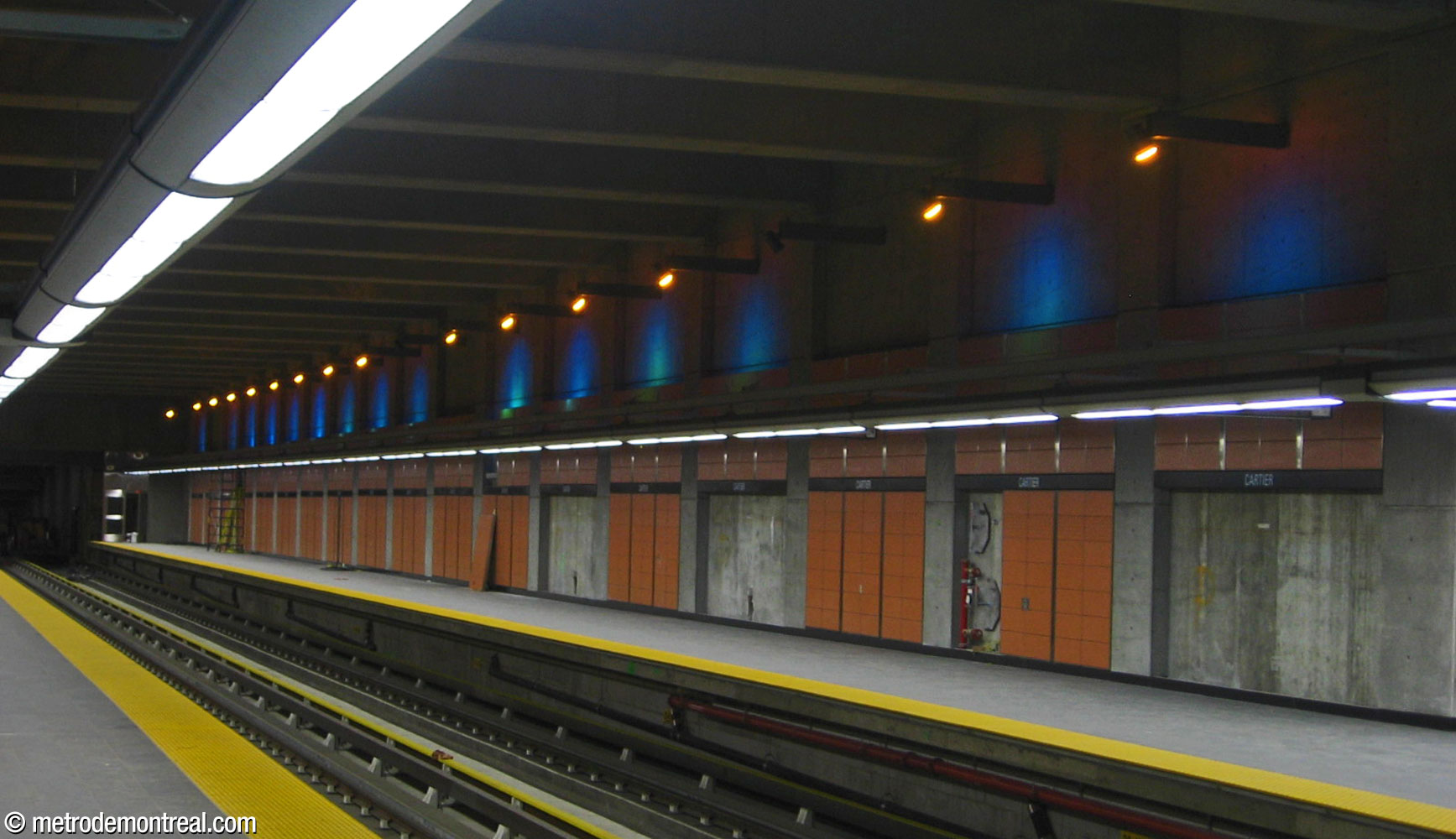 Panorama du quai avant l'ouverture de la station, montrant les panaches intenses de lumière bleue créés par les projecteurs.