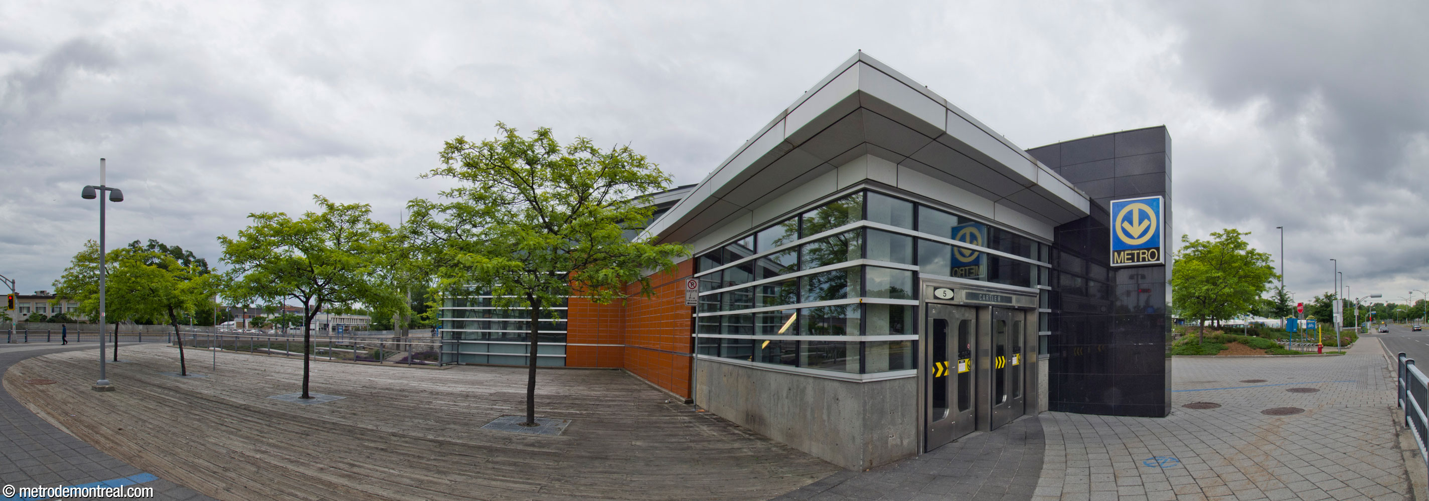 L'entrée nord de l'atrium de l'édicule principal se projette vers le boulevard Cartier. Les murs de verre autour de l'entrée sont encadrés par des pans de granit noir et de terre cuite glacée orange. À gauche, une terrasse de bois donne sur le jardin surbaissé; une partie de cette terrasse se trouve au-dessus du tunnel vers l'édicule secondaire.
