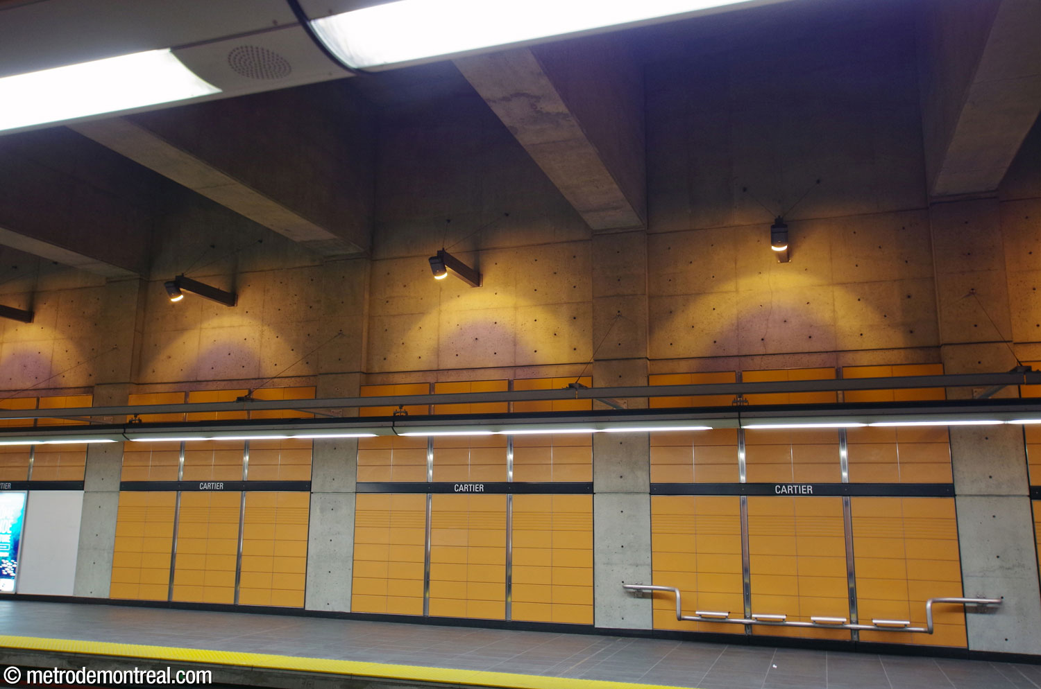 La charpente en béton de la nef divise les murs visuellement en travées, chacune revêtue de blocs de terre cuite orange et accentuée d'un faisceau de projecteur orange avec un centre bleu pâle.