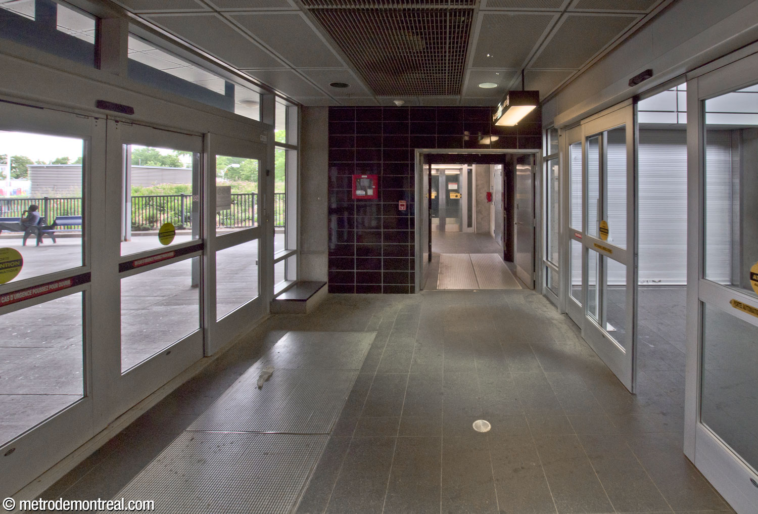 Le vestibule de la sortie de l'aire d'attente intérieure centrale du terminus d'autobus (droite) vers les jetées. Au centre, l'ascenseur vers le métro.