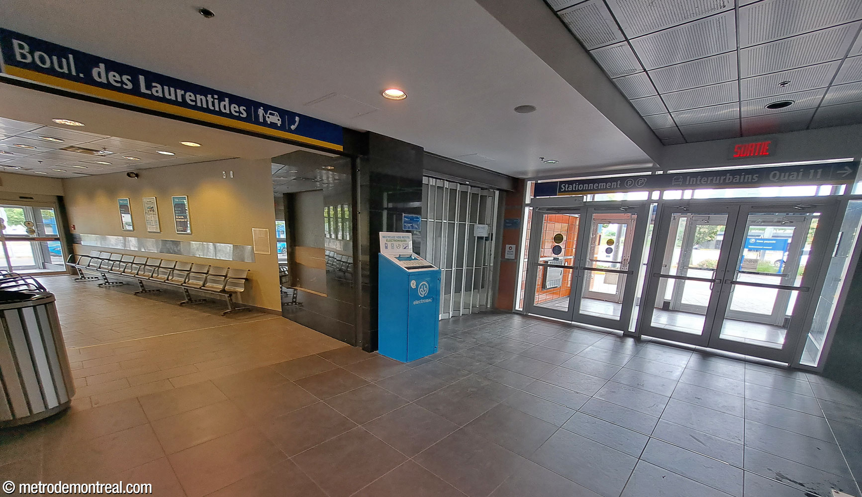 Une aire d'attente pour passagers d'autobus interurbains près de la sortie qui mène à l'arrêt de ces derniers ainsi qu'au stationnement, dans l'aile sud du secteur du terminus d'autobus de l'édicule principal.