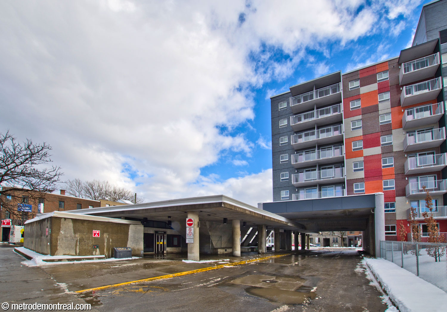 The station headhouse seen from the west. Note the partial integration into the adjacent apartment building, under which the bus loop passes.