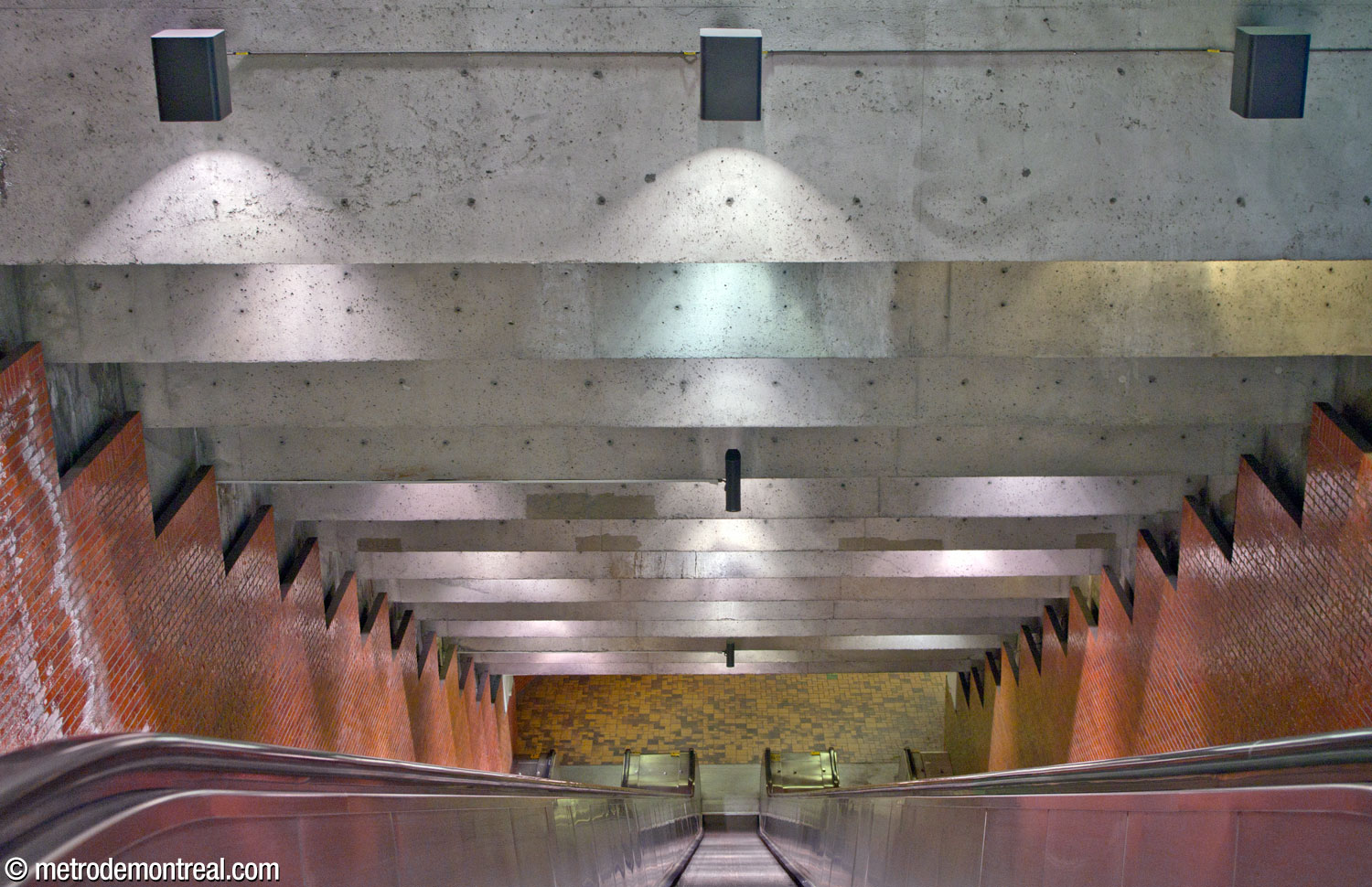 Escalator from the ticket hall to the platforms; the relatively low, stepped ceiling reduces the impression of depth.