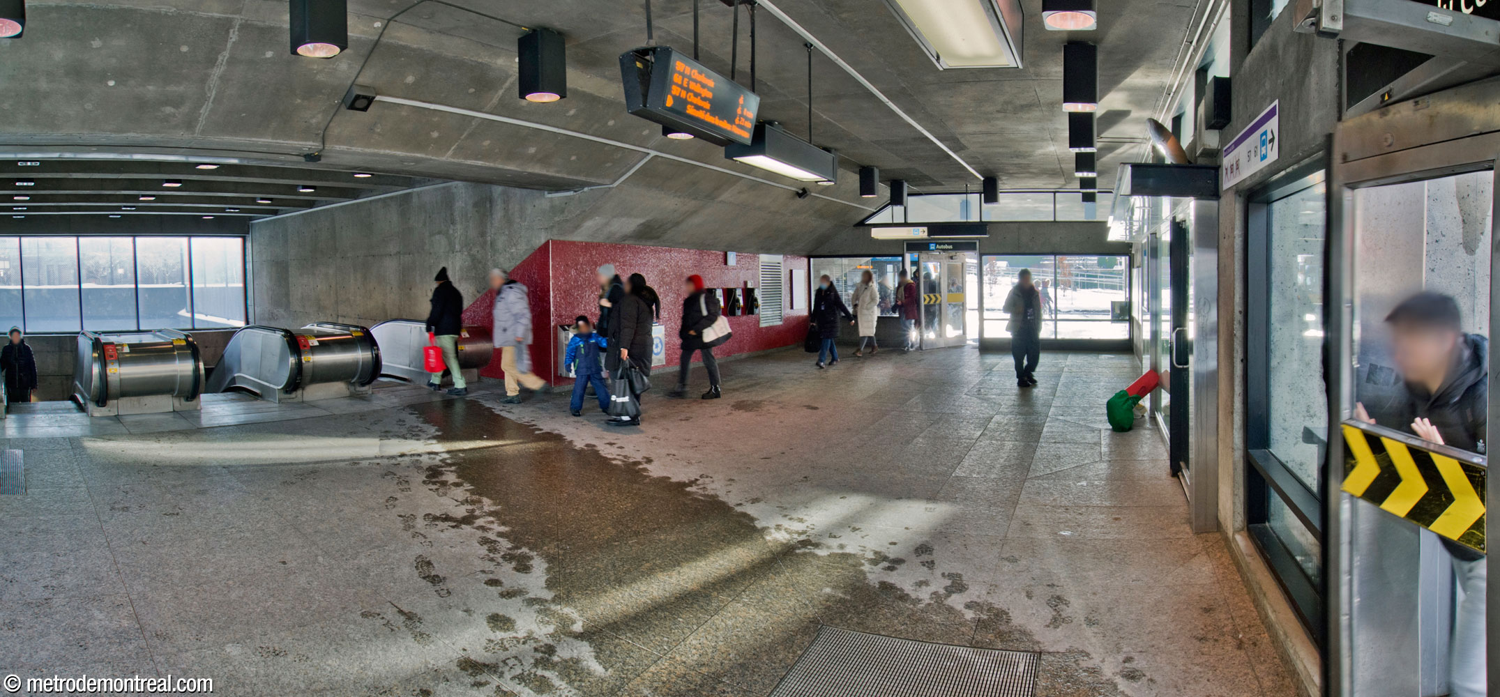 The interior of the headhouse. The far door leads to the bus loop; the main entrance is at right. The red wall was added to close off the space that formerly existed under the sloping ceiling that forms part of the mouth of the light shaft.