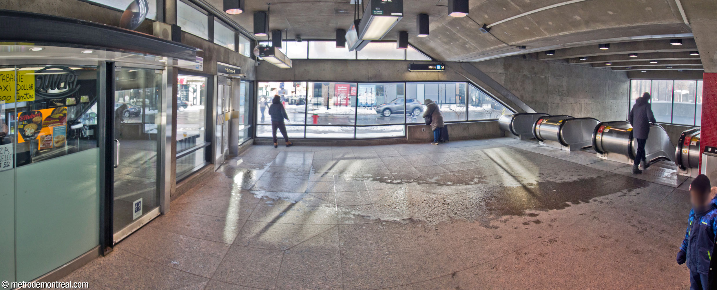 View from the west end of the headhouse, with the viewer's back to the bus loop. The main entrance is at left; the escalators to the ticket hall are at right.