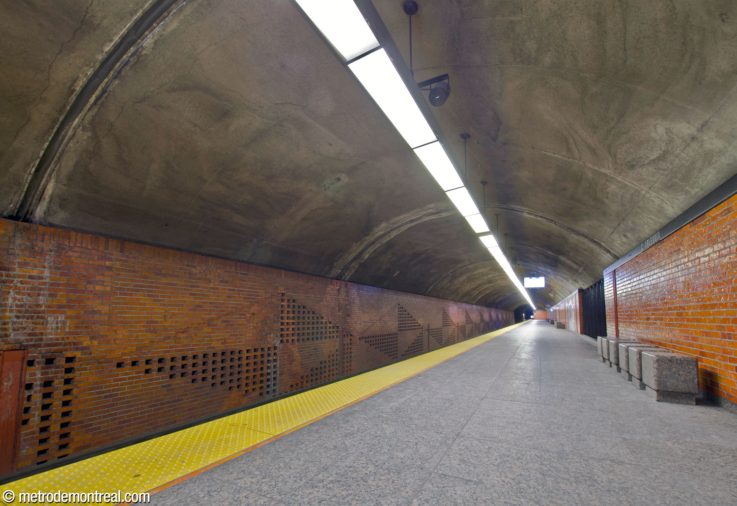 The Angrignon platform. The vaulted ceiling shows that this is the upper of the two platforms. Note the benches formed of rectangular granite blocks and the diamond patterns in the wall above the tracks, produced by omitted and recessed bricks.