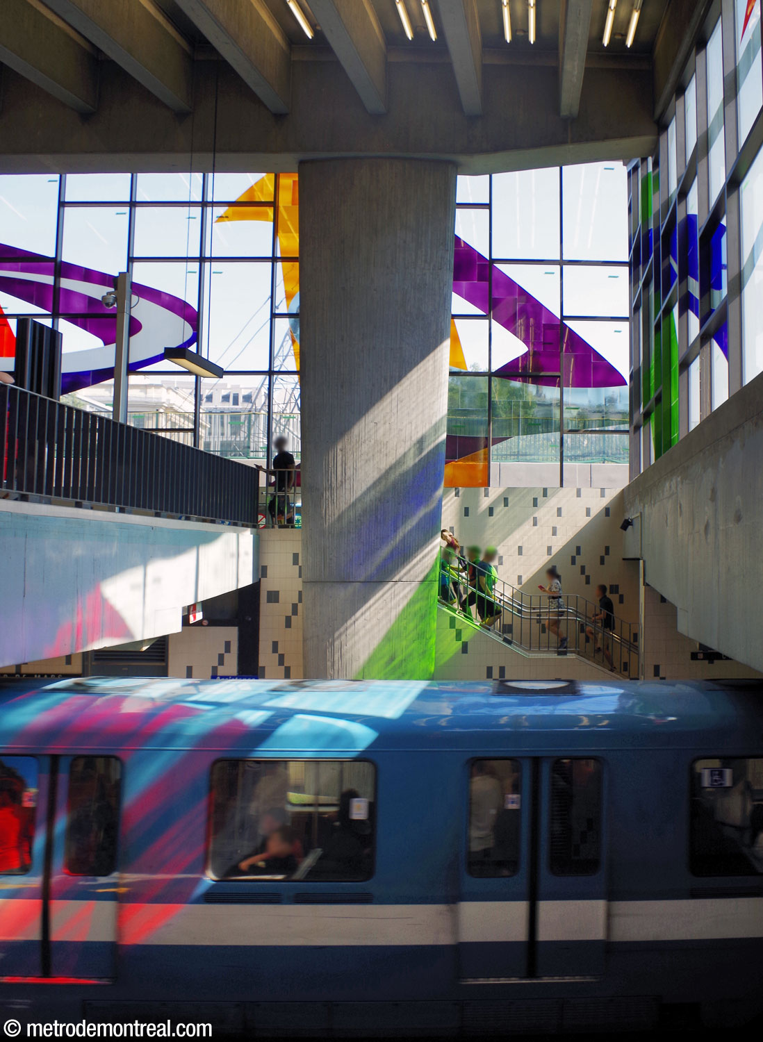 Coloured light streams from Marcelle Ferron's stained-glass window through the station volume onto a train.