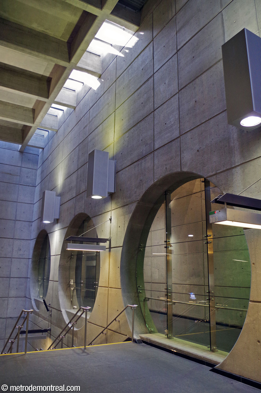 The row of circular windows in the north wall of the main volume, looking onto the hallway to the elevator from the ticket hall to the surface.