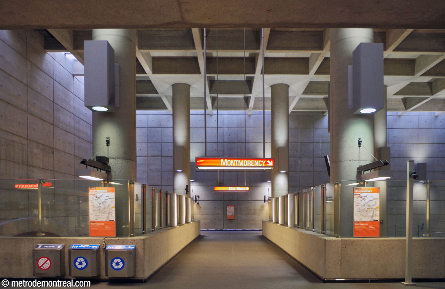 The crossover to the Côte-Vertu platform, seen from the ticket hall. The crossover is framed by the volume's supporting pillars and enclosed by glass walls for fire safety.