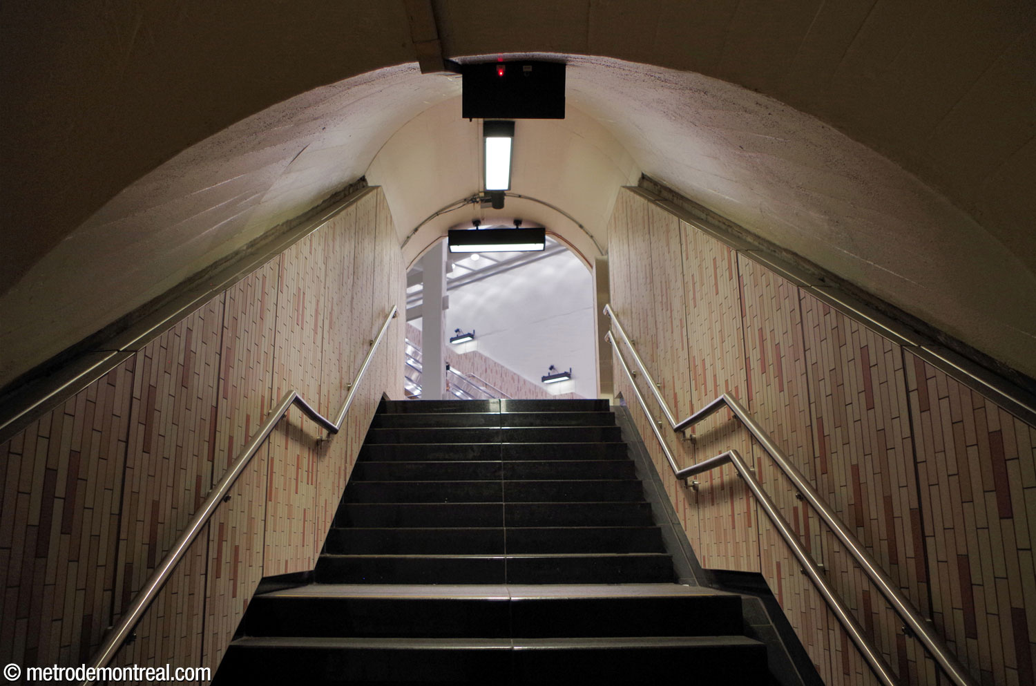 L’intérieur du tunnel qui contient l'escalier nord à partir du quai Côte-Vertu. On voit la tête de l’escalier déboucher sur le grand volume.