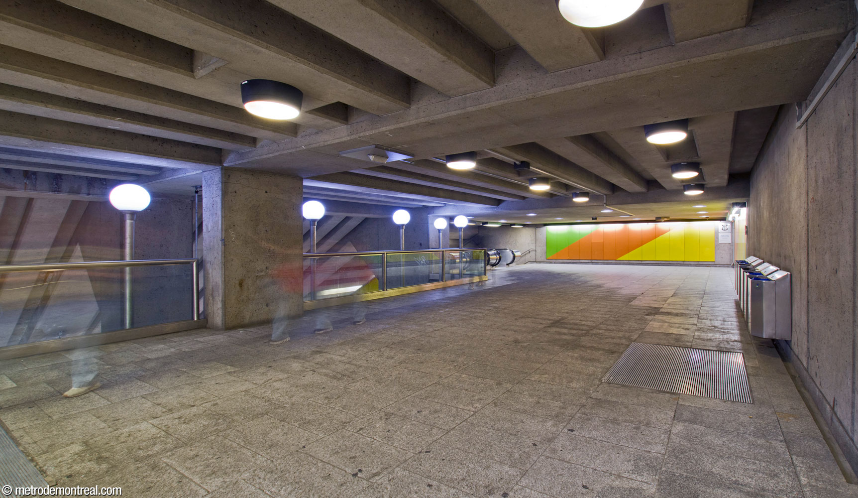 Vue le long du passage au-dessus du grand volume. On regarde vers le nord et la tête des escaliers vers la billetterie. Au bout du corridor, on voit une murale de Gilbert Sauvé.