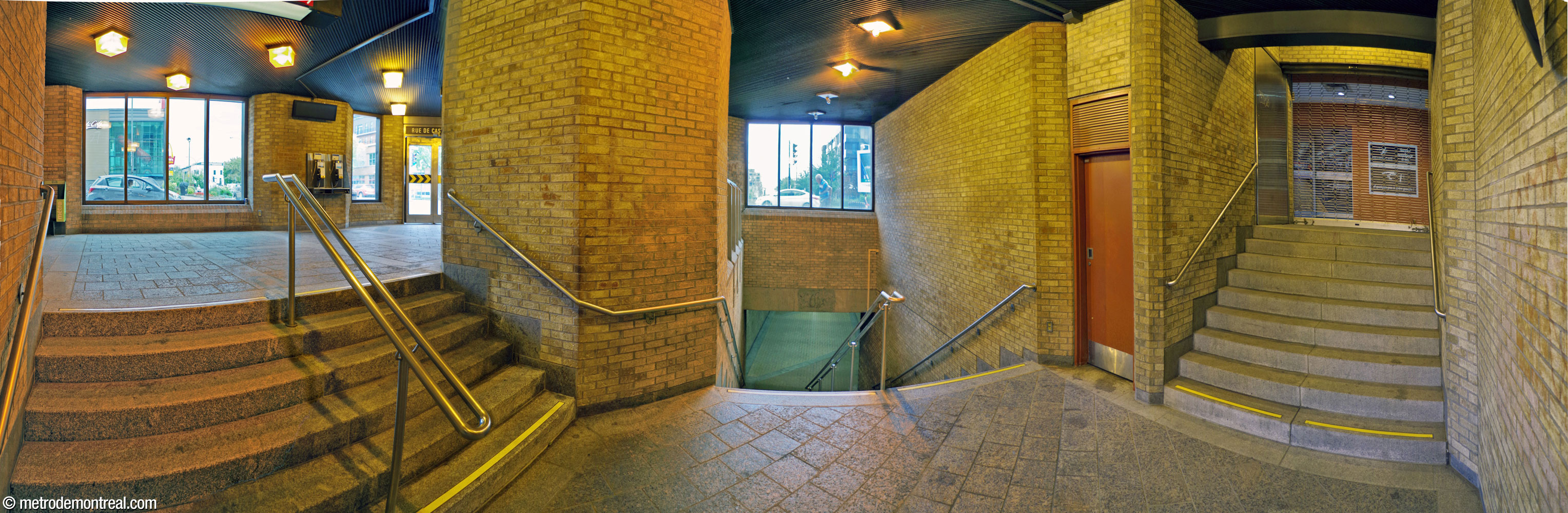 Interior of the Saint-Laurent Est access. The entrance doors open onto the landing at left; the corridor to the ticket hall is at centre. At right, a staircase leads to an indoor access, apparently permanently closed to the public, to the adjoining building.