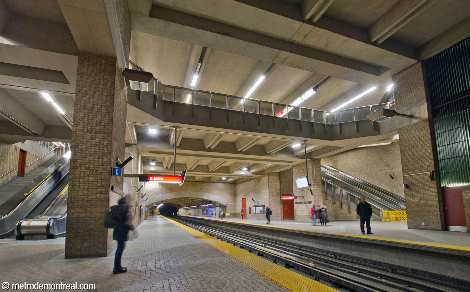 The main volume looking east from the Snowdon platform. The tall stairwells leading to the ticket hall are seen on either side. Above, the mezzanine housing the ticket hall overlooks the volume.