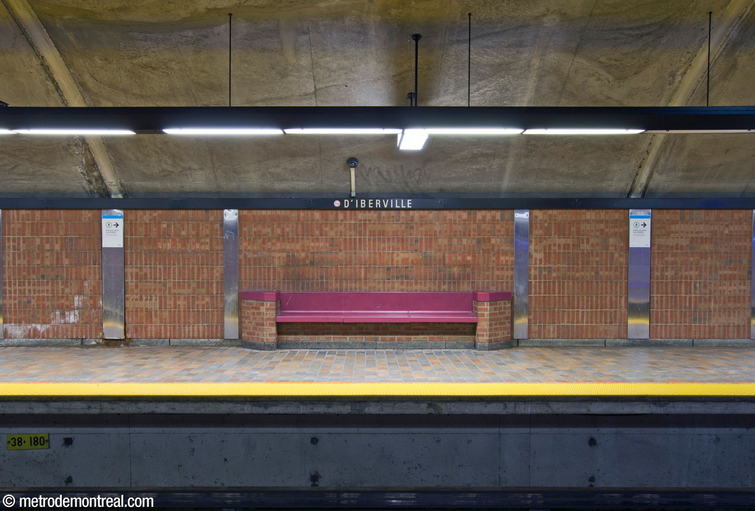 One of the deep carmine benches along the platforms.
