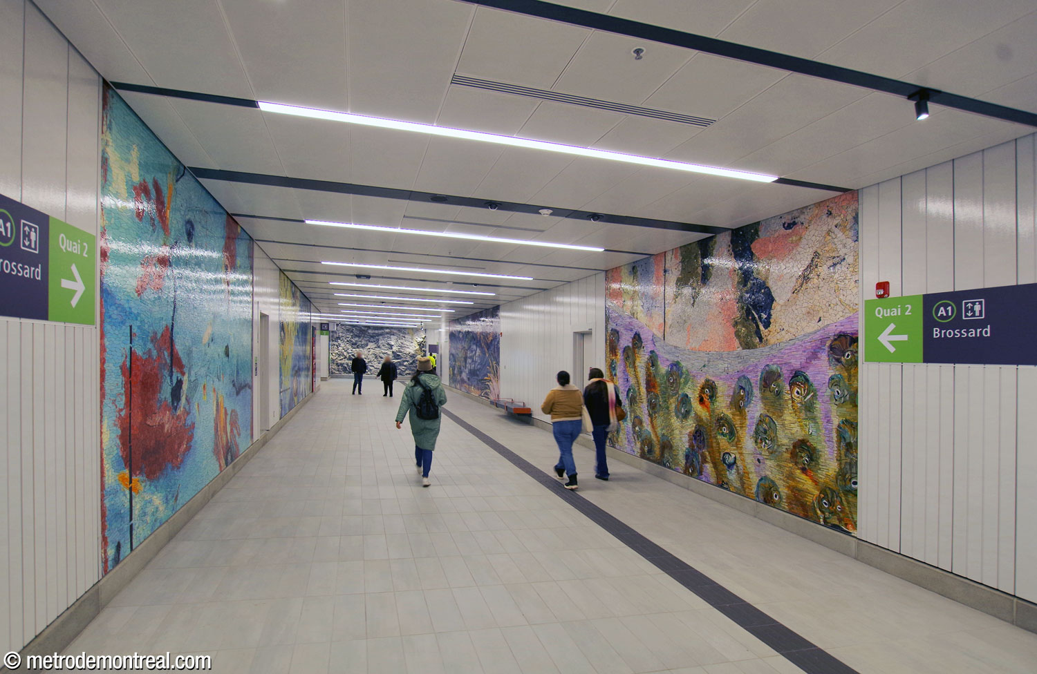 Le corridor du transept entre la salle de contrôle et les quais est égayé par cinq grandes mosaïques hautes en couleurs, une œuvre sous le titre Le Mont habité et signée Manuel Mathieu. On voit ici quatre des cinq mosaïques, entre les deux escaliers vers les quais; la cinquième est plus près de la barrière de perception.