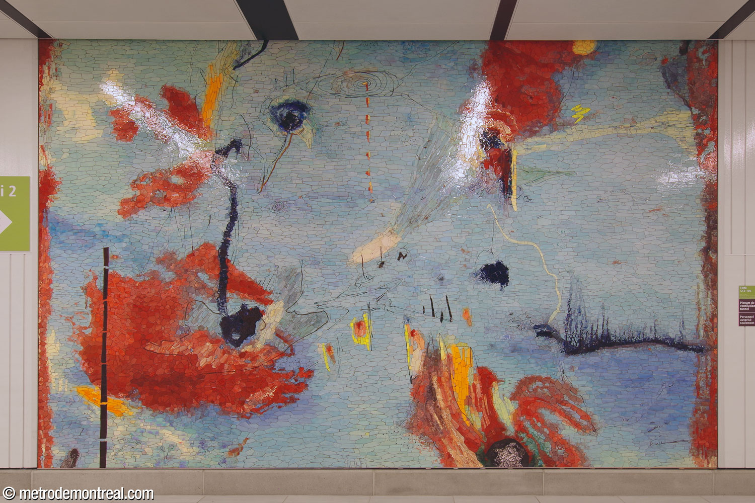La deuxième section de l’œuvre Le Mont habité de Manuel Mathieu, une mosaïque abstraite en bleu ciel et rouge, située sur le mur sud du corridor du transept, près de l’ascenseur vers le quai 1.