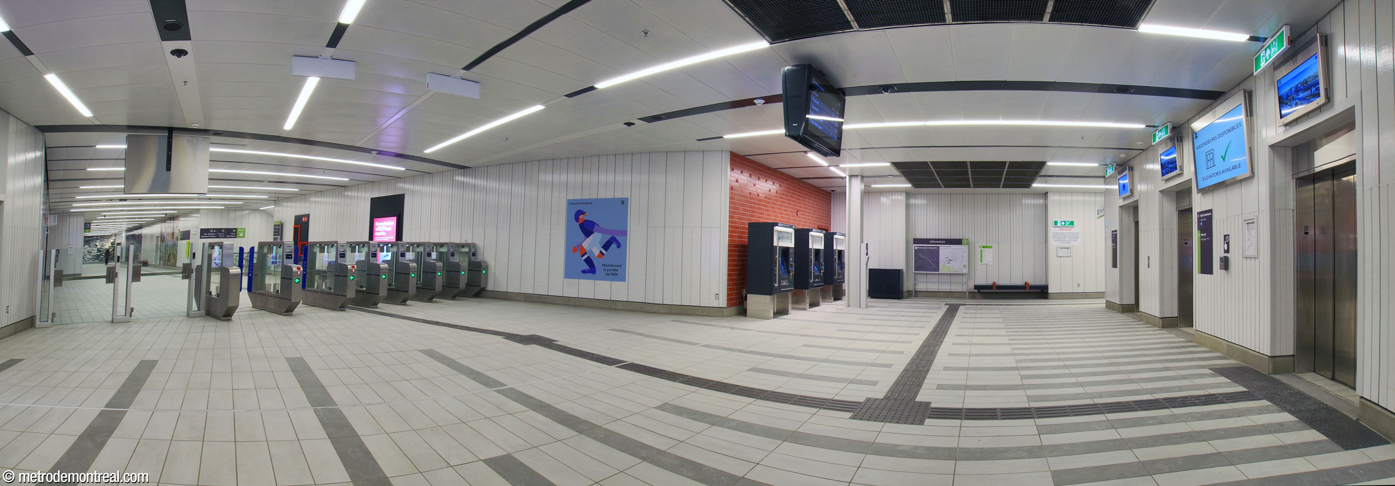 La billetterie de la station du REM. Les ascenseurs sont à droite, avec des écrans qui indiquent leur statut. À gauche, la barrière de perception mène vers le corridor donnant accès aux quais.