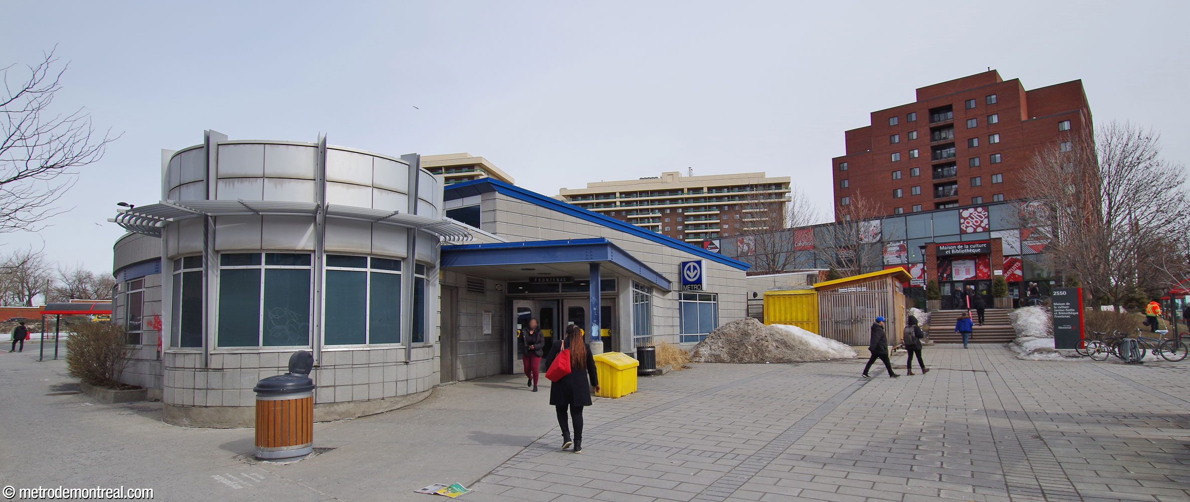 Côté ouest de l'édicule. La place adjacente à l'édicule, qui sert aussi de parvis pour le centre culturel avoisinant, accueille un marché public en été. La section circulaire de l’édicule à gauche contient un local pour chauffeurs d’autobus.