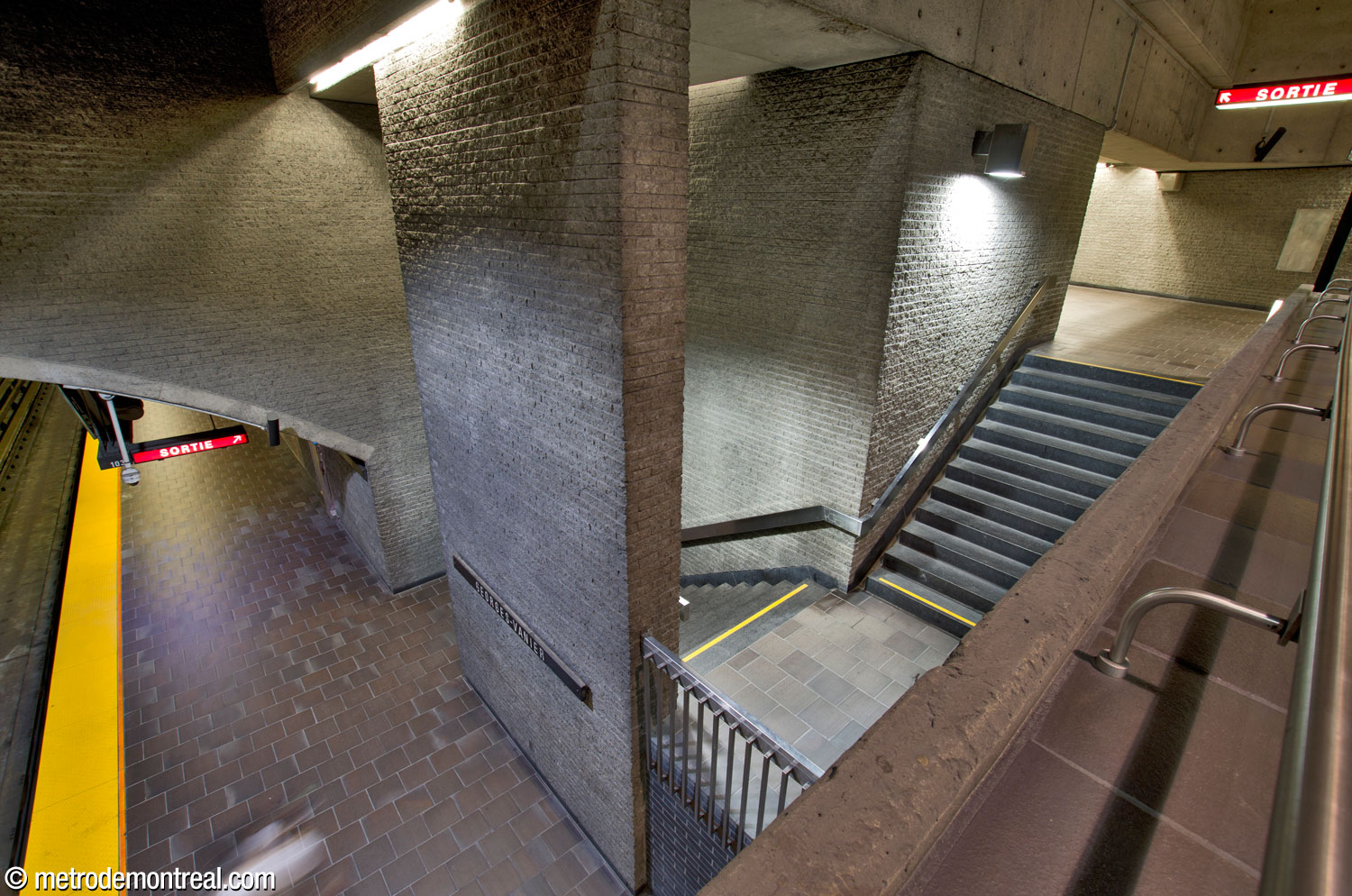 Vue depuis la passerelle sur l’escalier ouest vers le quai Côte-Vertu. Cet escalier descend directement vers le quai avant de bifurquer vers la droite et passer derrière un mur-écran.