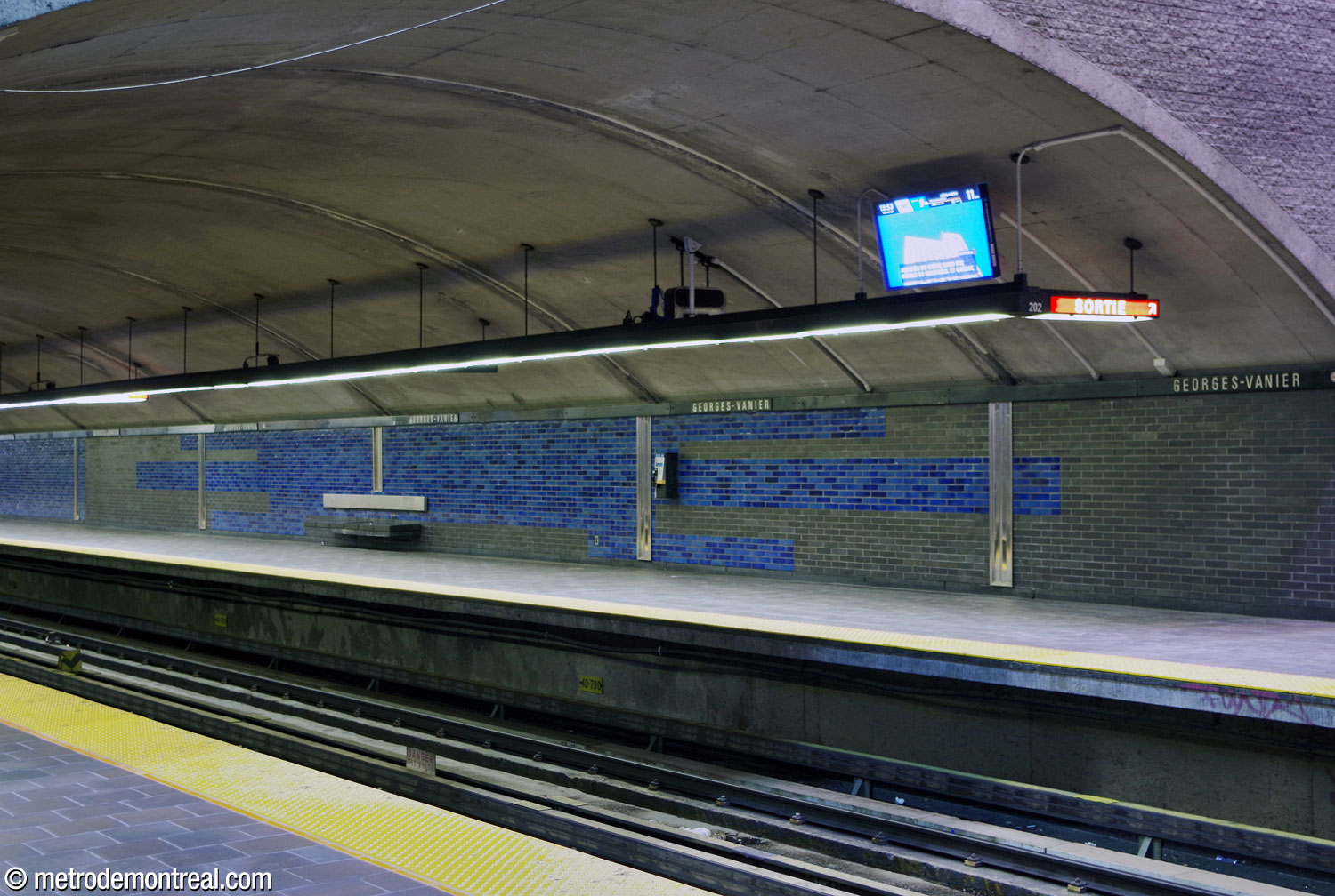 Des motifs horizontaux constitués de briques glacées de gris ardoise et bleu parent les murs des quais construits en tunnel. Les bancs sont constitués de sièges en granit gris foncé et des dossiers en acier inoxydable.